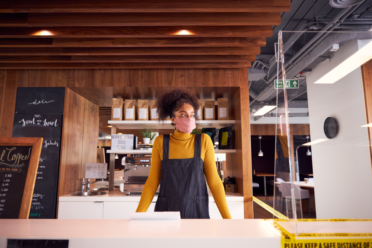 Small Business Owner Of Coffee Shop In Mask Standing Behind Counter